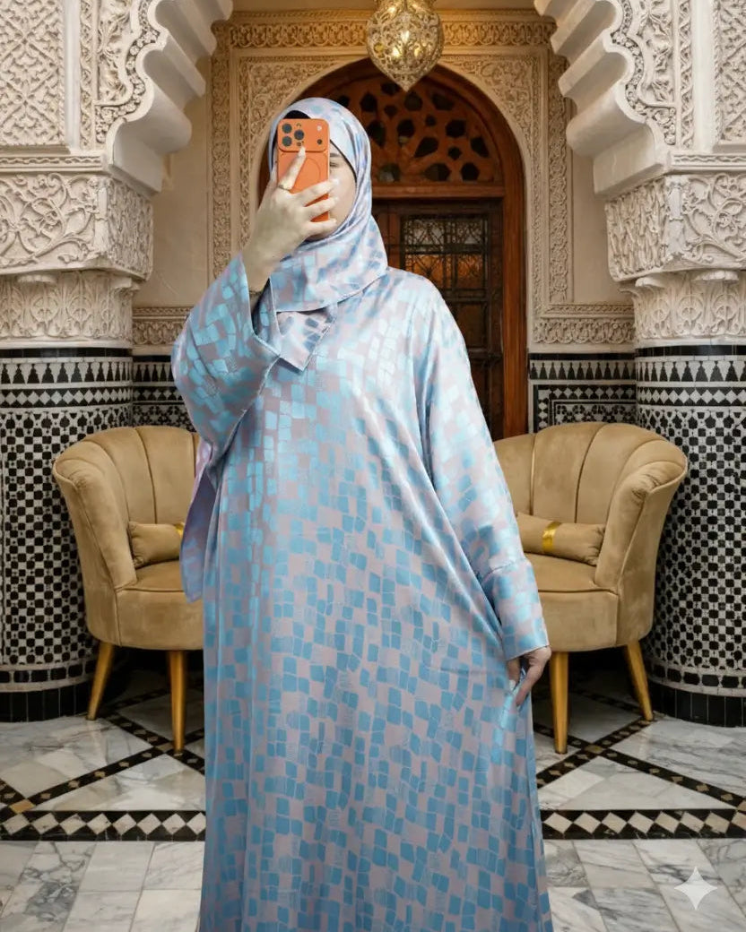 Person wearing a light blue patterned dress in an ornate room with arches and chairs.